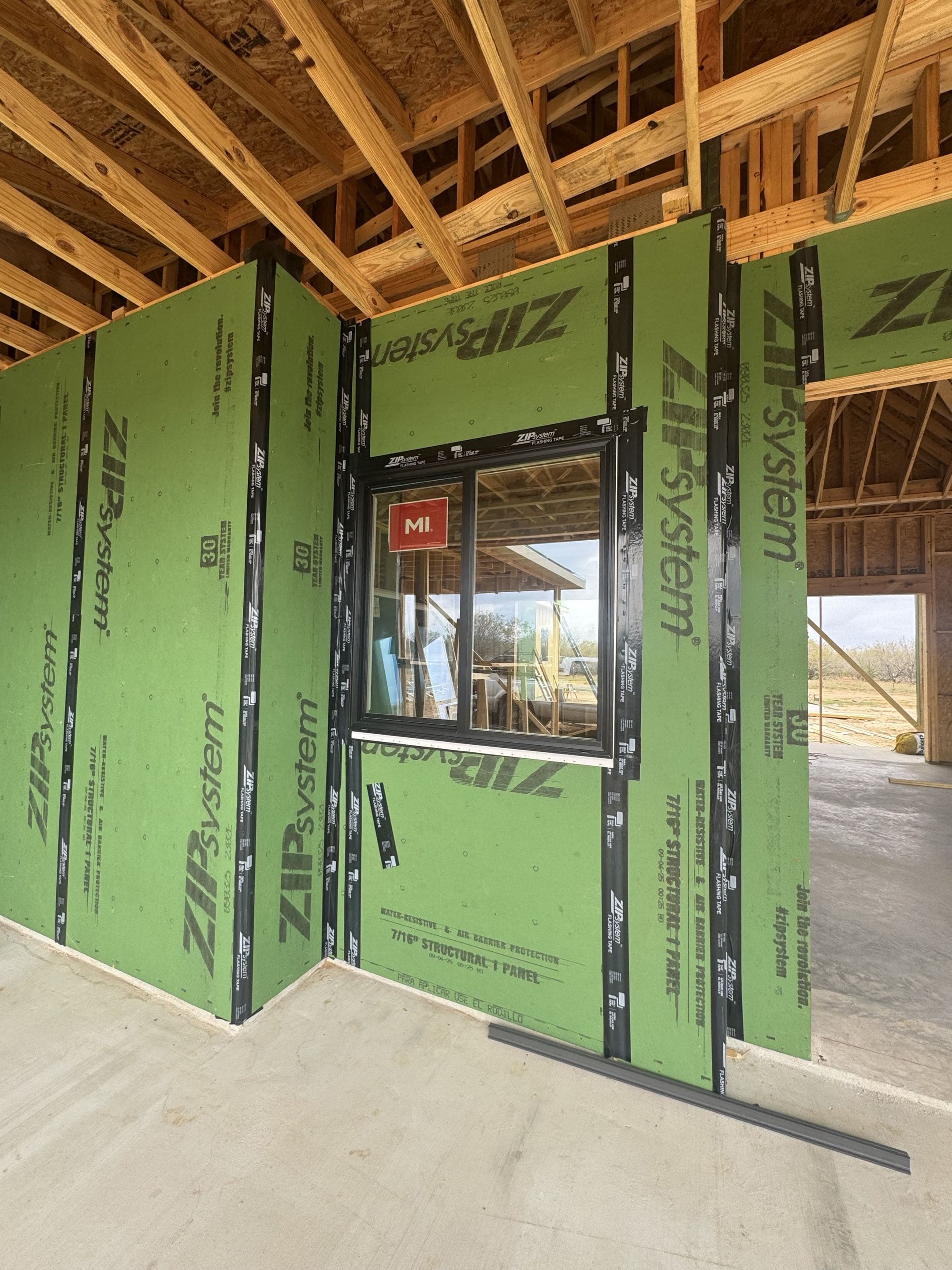 ZIP System green structural sheathing panels with flashing tape on Ryan's custom home build in Seguin TX